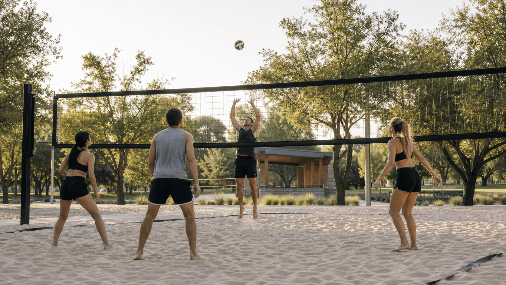 Players enjoying a volleyball game on a sand court in a city park